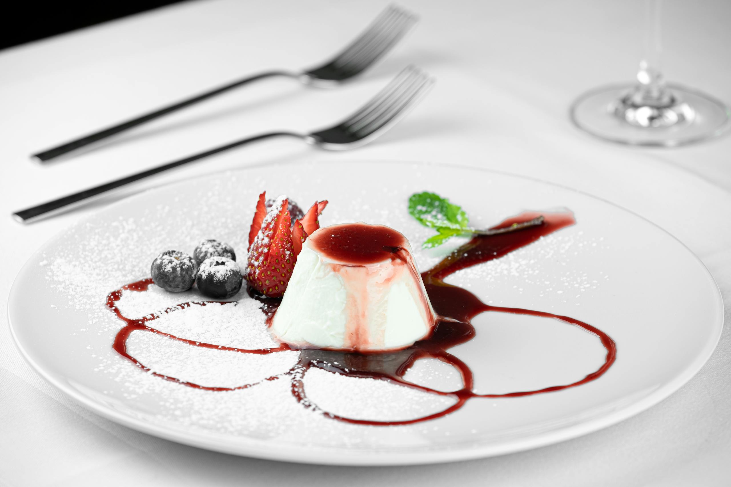 Delicious panna cotta dessert with fresh berries and mint, elegantly plated.